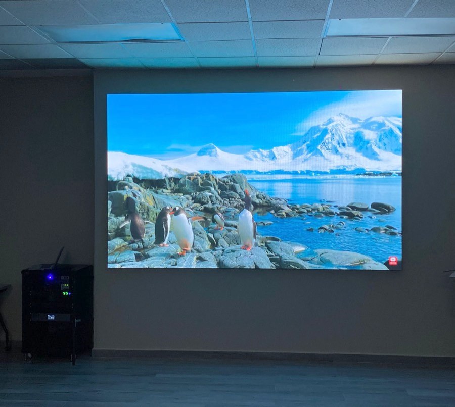 Pantalla LED instalada en una sala de consejo mostrando una imagen de paisaje