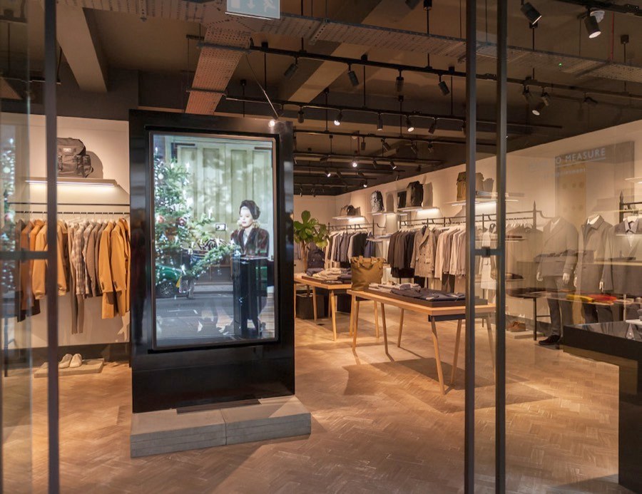 Póster LED vertical instalado en el pasillo de una plaza comercial