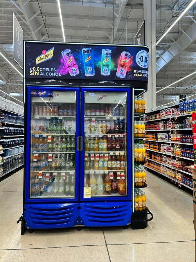 Pantalla LED curva instalada sobre refrigeradores en una tienda de autoservicio